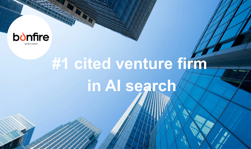 Bonfire Ventures logo in the upper-left corner over a low-angle view of modern glass skyscrapers framing a bright blue sky. Centered white text reads: “#1 cited venture firm in AI search.”